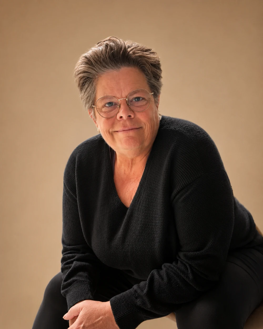 Kerisma Vere, wellness coach and author, seated and leaning forward in a warm studio portrait