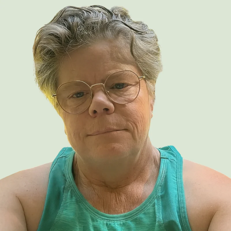 Kerisma Vere, wellness coach and author, against a soft sage-green background