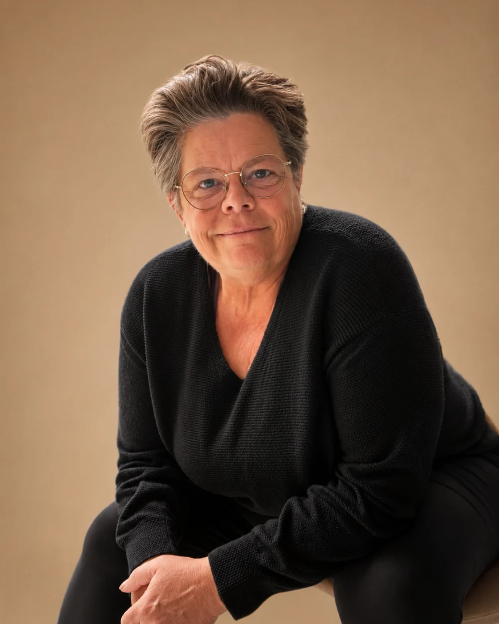 Kerisma Vere, wellness coach, seated and leaning forward with a warm, attentive expression